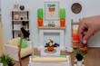 Lovely light dollhouse interior, Living room with white rustic furniture and bright decor, A hand putting a basket with carrots on the floor