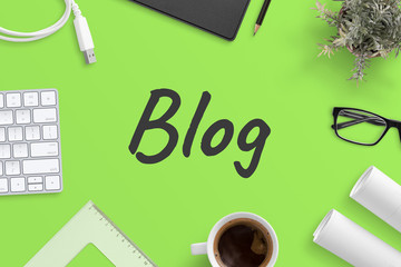 Poster - Blog text on green office desk surrounded with writing, office supplies. Blogging concept, top view, flat lay.