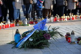 Fototapeta  - Wieniec kwiatów z flagą Unii Europejskiej i szarfą Rady Miasta Krakowa złożone na krakowskim Rynku po zamordowaniu prezydenta Gdańska Pawła Adamowicza, w tle rozmyte znicze, zgromadzeni ludzie