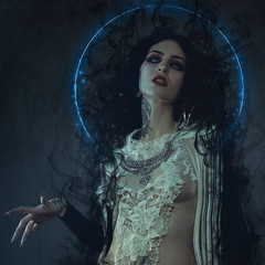 vampire, demonic woman dressed in white lace and silver jewelry. has fangs and thick brown hair