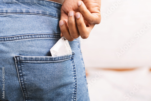 Fotografía Man taking condom from jeans back pocket