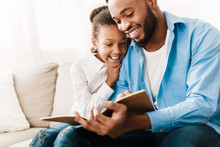 Little Girl And Father Enjoying Reading Book Together