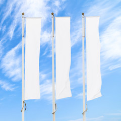 Wall Mural - Three blank white flags on flagpoles against cloudy blue sky, corporate flag mockup to ad logo, text or symbol, company identity flag template with copy space