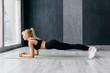 © MZaitsev - Athletic woman doing plank exercise in white sunny gum