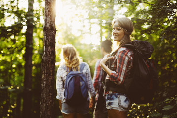 Wall Mural - beautiful woman and friends hiking in forest