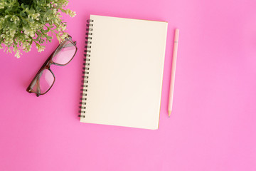 Wall Mural - blank notebook and pencil on pink background, flat lay photo of notebook for your message