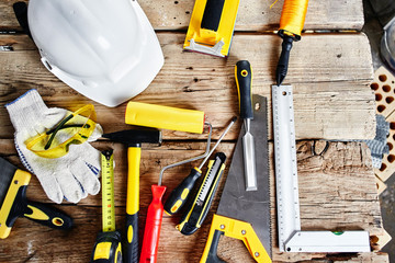 set of construction tools on a wooden background top view