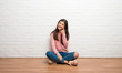 © luismolinero - Teenager girl sitting on the floor in a room looking to the front