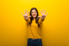 Teenager Girl On Vibrant Yellow Background Counting Ten With Fingers