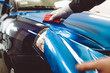 © hedgehog94 - Car wrapping specialist putting vinyl foil or film on car. Selective focus.