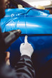© hedgehog94 - Car wrapping specialist putting vinyl foil or film on car. Selective focus.