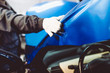 © hedgehog94 - Car wrapping specialist putting vinyl foil or film on car. Selective focus.
