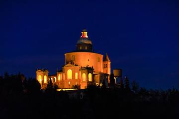 Closeup of scenic Sanctuary of Blessed Virgin of San Luca on Colle della Guardia in Bologna illuminated by night. Historical church and pilgrimage destination in Emilia-Romagna, Italy. Famous landmark