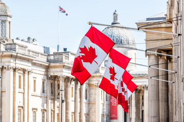 london, uk high commission of canada with closeup of row of red colorful canadian flags on cockspur 