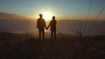 Wall Mural - Loving couple on peak looking at sunset