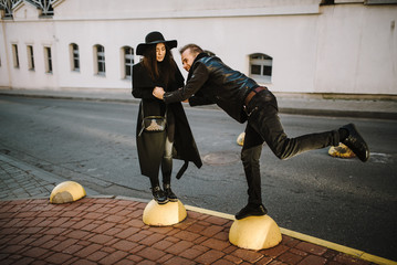 Young couple in love outdoors. Stunning sensual outdoor portrait of a young stylish fashion couple, creating a spring in the city