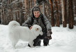 © Vadym - people playing with funny dog in winter forest