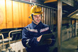 © dusanpetkovic1 - Close up of supervisor dressed in protective suit using tablet while standing in heat plant.