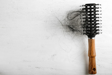 Brush with fallen down hair on white wooden table