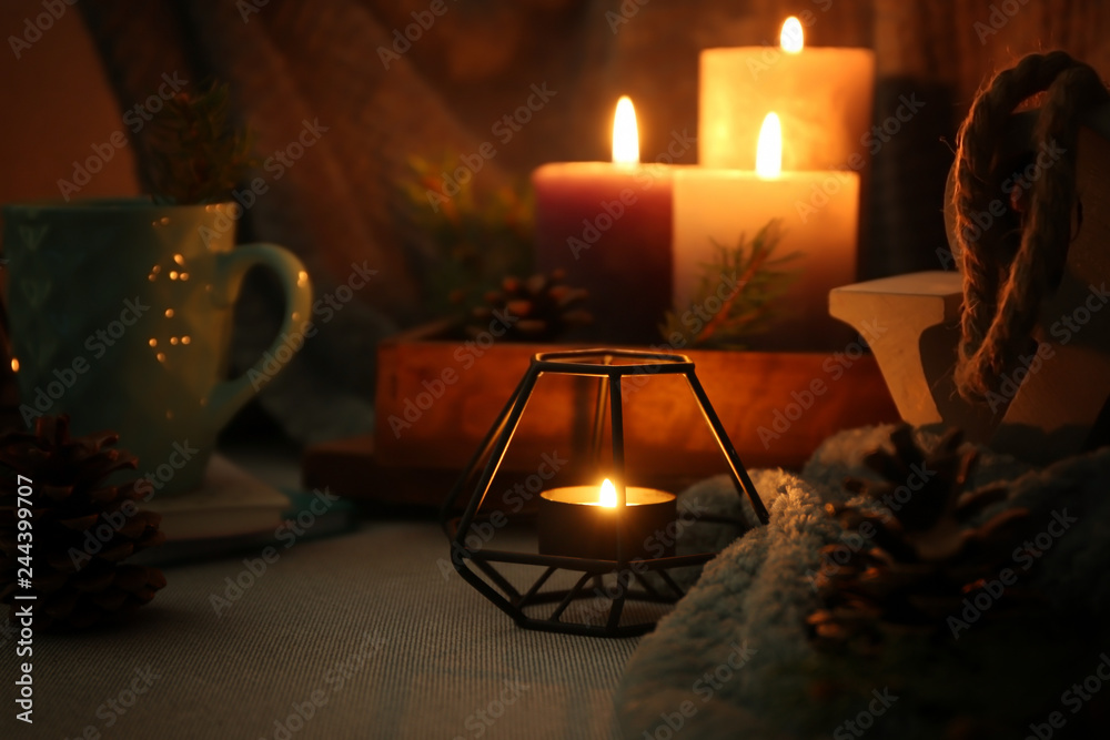 Beautiful burning candles with decor on sofa