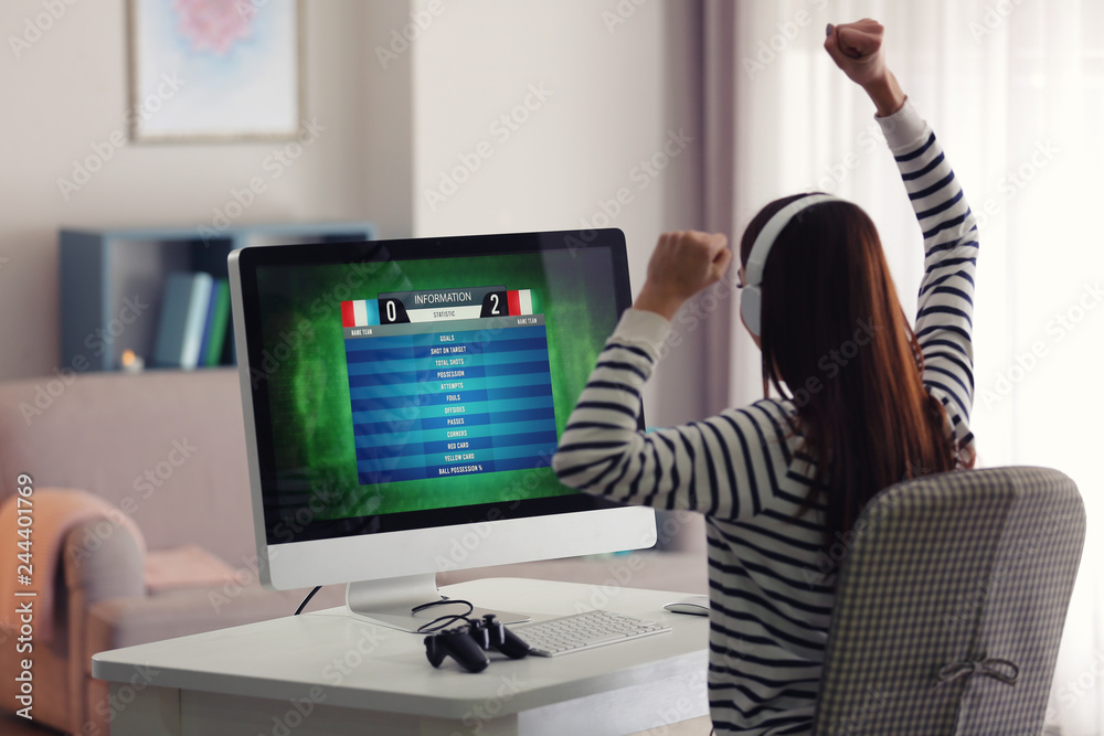 Emotional young woman playing computer game at home