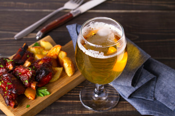 Wall Mural - Glass of beer and grilled pork spare ribs with fry, tasty snack to beer. Beer and food concept. Ale and meat