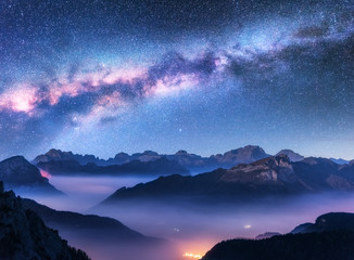 Wall Mural - milky way above mountains in fog at night in autumn. landscape with alpine mountain valley, low clou