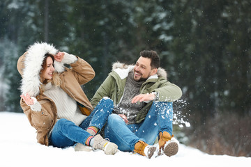 Canvas Print - Couple spending time outdoors on snowy day. Winter vacation