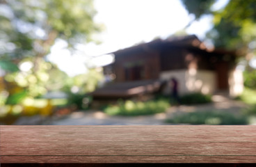 Empty wooden table in front of abstract blurred green of garden and house background. For montage product display or design key visual layout - Image.