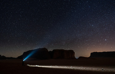 Wall Mural - Explorer in desert at night with starry sky in Wadi Rum desert, Jordan