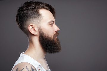 bearded hipster. Boy with stylish haircut and tattoo