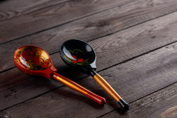 Wooden spoons, painted with floral ornament in the style of Khokhloma Russian wood art. Two spoons with a traditional pattern.