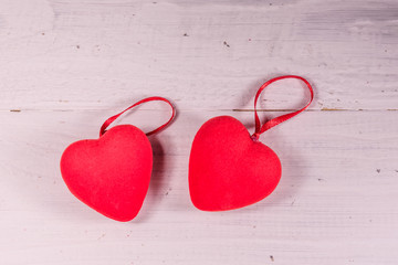 Two red hearts on a white wooden table. Top view