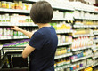 © Right 3 - Woman Shopping at Grocery Market Pharmacy. Supermarket Shopper Doing Groceries. Female Holding Basket Trying to Decide which Products to Buy. Retail Healthcare Medicine, Vitamins, and Supplements.
