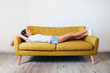 © GVS - Happy young woman relaxing on couch at home
