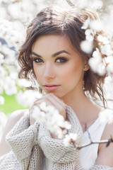 Close up portrait of young beautiful woman on spring background. Attractive young girl with flowers. Spring make up model.