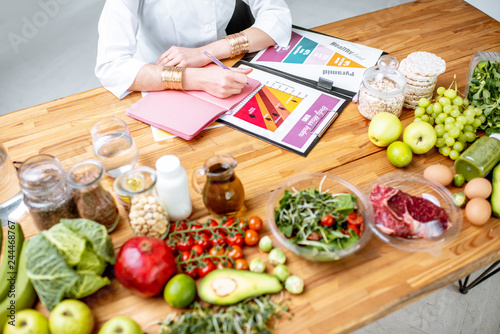Cuadros en Lienzo Dietitian writing diet plan, view from above on the table with different healthy
