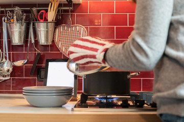 woman cooking while reading recipe on tablet