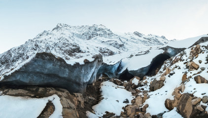 Canvas Print - Alibek snow-covered mountain and the base of the glacier and the entrance to the ice cave under the ice, Alibek, Dombay