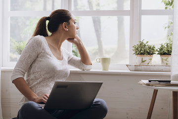 Wall Mural - Young woman networking with her laptop at home