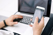 © yurolaitsalbert - close up. the businessman uses a smartphone and a laptop in the workplace.