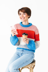 Sticker - Happy cheerful girl wearing sweater sitting on a chair