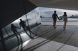 © WellStock - Rear view of couple standing in the hall with high-tech interior near the window with scenic view. Holding hands. Love story. Opera House, Oslo