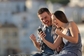 Wall Mural - Excited couple or friends reading phone content