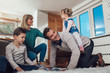© Mediteraneo - Happy family having fun on floor of in living room at home, laughing.
