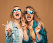 © halayalex - Two young beautiful smiling hipster girls in trendy summer clothes and sunglasses. Sexy carefree women posing on golden background in studio. Positive screaming models