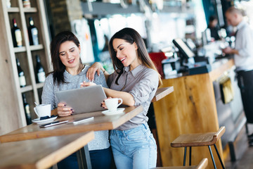 Wall Mural - Smiling couple using laptop in cafe