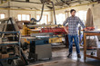 © mavoimages - Woodworker leaning on a table in his large workshop