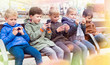 © JackF - Kids playing with smartphones on bench
