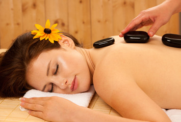 Wall Mural - Stone therapy. Woman getting a hot stone massage at spa salon